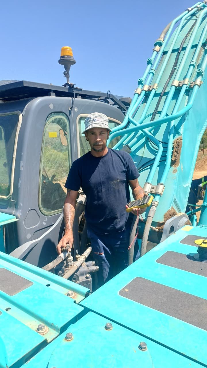 C.J Auto Electrical technician performing electrical diagnostics on an excavator on site